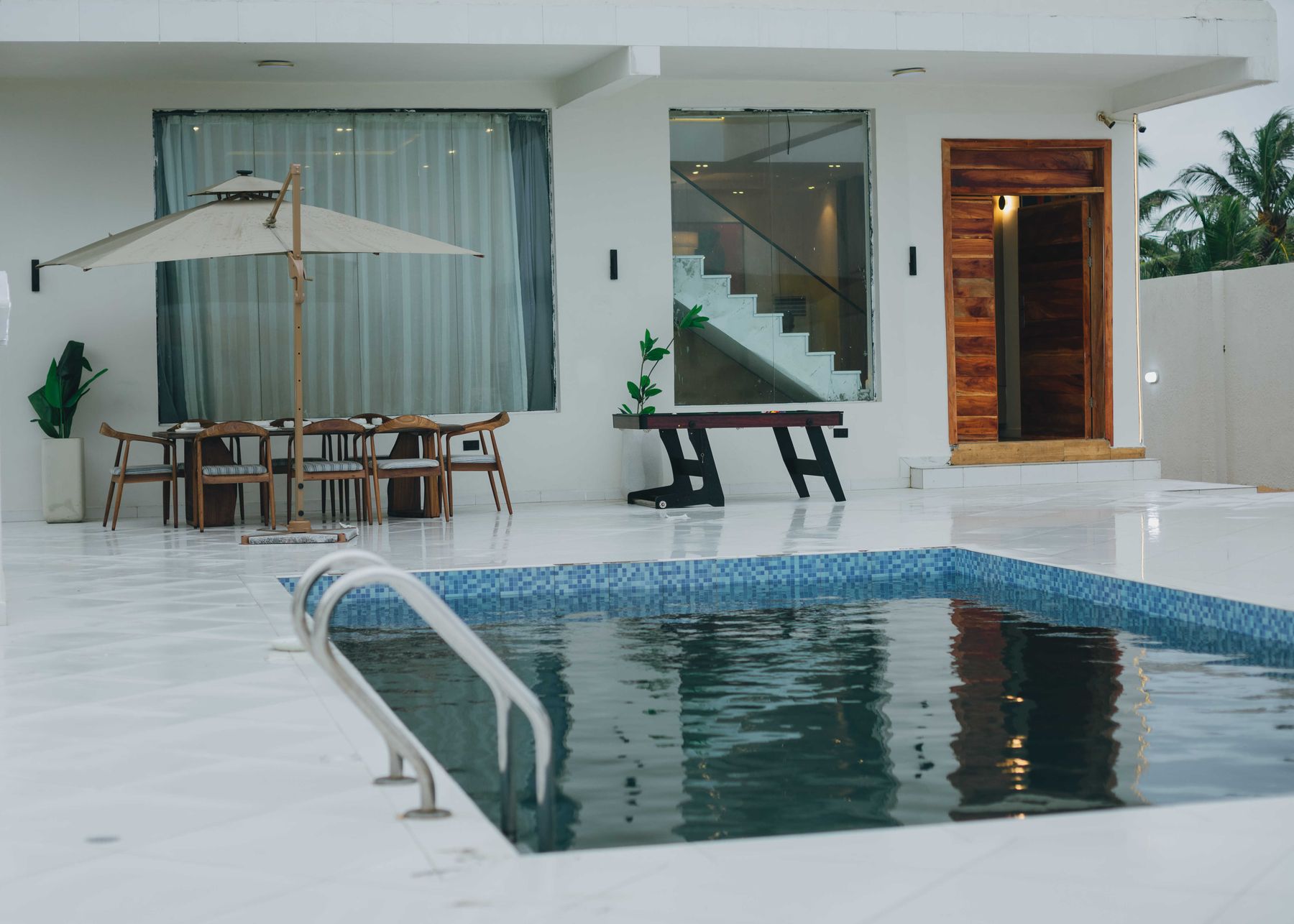 The pool set into the white terrace beside the house